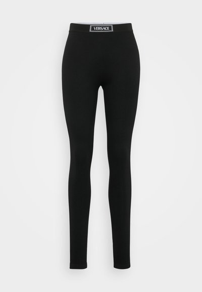 Colanți negri dintr-un material elastic, cu un brâu elastic înalt, prezentând o etichetă albă cu logo, design aderent și textură netedă.
