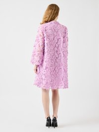 Lavender floral embroidered dress with sheer fabric, long sleeves, knee-length hem, and a textured 3D flower pattern. Black high heels visible.