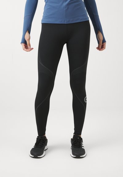 Musta legginsit, joissa on tiukka malli, sisältävät tekstuuripainatuksia ja logoyksityiskohdan alaleuassa. Valmistettu joustavasta materiaalista, joka sopii urheilukäyttöön.