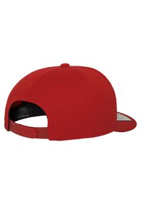 Rød snapback kasket med flad skygge. Den er lavet af slidstærkt stof, har en tekstureret overflade og en justerbar plastikrem bagpå.