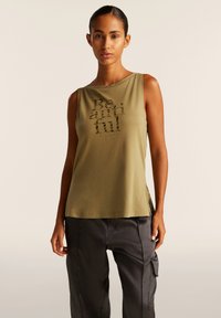 Top senza maniche verde oliva con scollo tondo, caratterizzato da testo stampato "Be beautiful" in un materiale lucido, fessure laterali e texture morbida.