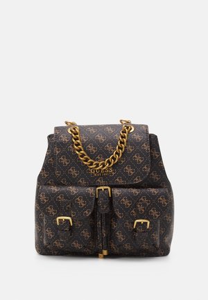 Sort Guess-rygsæk med brun logo-tryk, guldkæde som håndtag, to forlommer med spænder og teksten "GUESS EST 1981" på klappen.