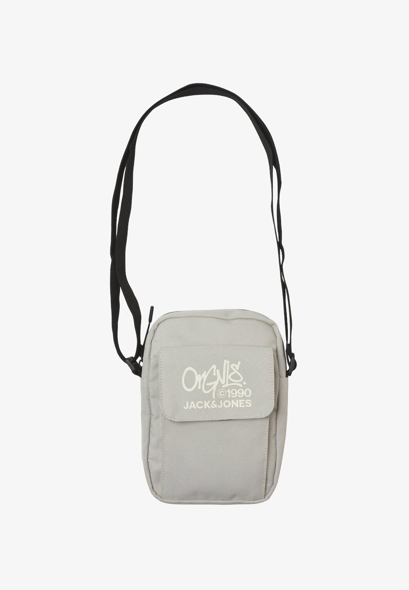 Grijze stoffen crossbodytas met een voorflap en witte logo-accenten. Heeft een lange verstelbare zwarte band en een rechthoekige vorm.