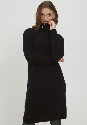 Strickkleid in Schwarz mit hohem Kragen und halbem Reißverschluss. Hat einen lockeren Schnitt und eine gerippte Textur, die bis zur Kniehöhe reicht.
