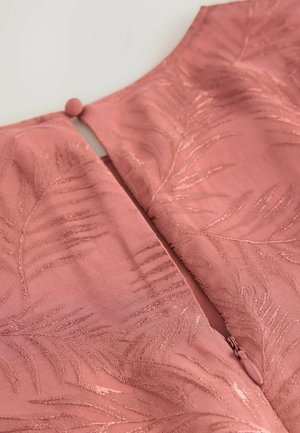 Rozā audums ar lapu rakstu nedaudz teksturētā apdarē. Ietver aizmugurējo rāvējslēdzēju un apaļu pogu aizdari pie kakla.