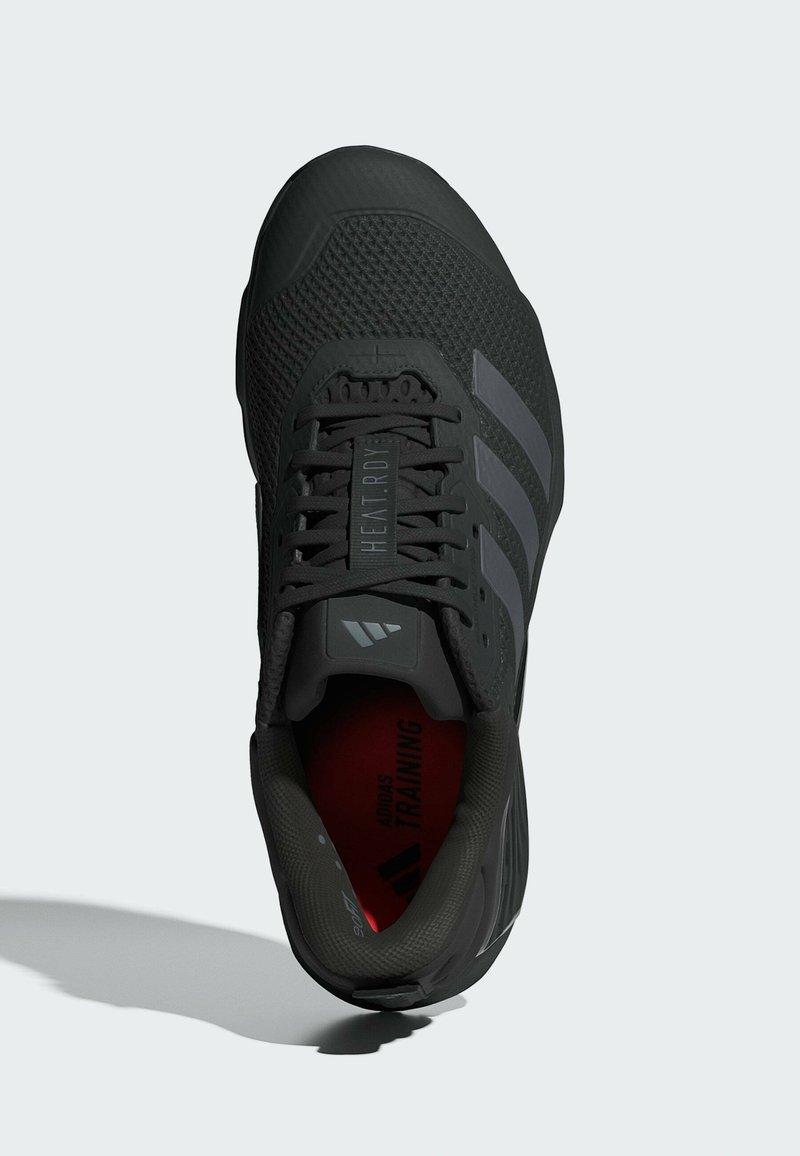 Scarpa sportiva nera con una parte superiore in mesh testurizzata, tre strisce grigie, dettagli riflettenti e una soletta rossa con la dicitura "ADIDAS TRAINING."