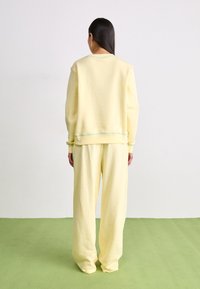 Nike Sportswear PANT - Tracksuit bottoms - alabaster