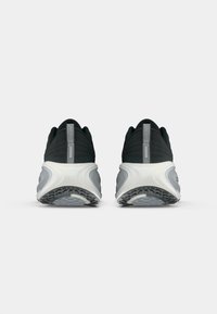 Μαύρα αθλητικά παπούτσια με αναπνεύσιμο πλέγμα επάνω, μαλακή επένδυση στον άνω μέρος, γκρι λεπτομέρειες και υφασμένο λευκό μεσαίο σόλο με σχεδιασμένη λαστιχένια σόλα.