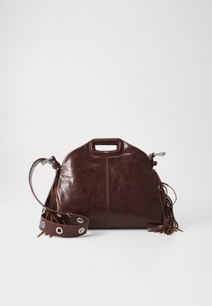 Sac à main en cuir marron avec une forme structurée, dotée d'une anse supérieure, d'une bandoulière à franges amovible et d'accents en métal argenté.