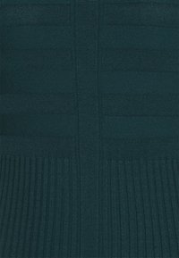 Dunkeltürkis gestrickter Pullover mit horizontalen und vertikalen Rippstrukturen, mit einem gefältelten unteren Abschnitt für zusätzlichen Detail.