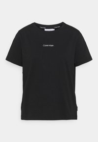 Czarna bawełniana koszulka z okrągłym dekoltem i krótkimi rękawami. Posiada małe białe logo "Calvin Klein" umieszczone na środku klatki piersiowej.