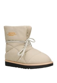 Beige gepolsterter Knöchelstiefel mit gestepptem Design, runder Zehenpartie und weißem Schnürverschluss. Ausgestattet mit einer schwarzen Gummisohle und einem orangefarbenen Logo am Schaft.