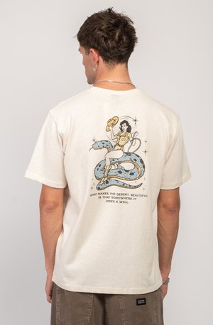 Crèmekleurig katoenen T-shirt met een grafische print van een vrouw met een hoed en een slang, met tekst aan de onderkant. Korte mouwen ontwerp.