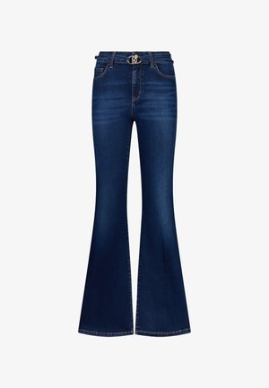 Jeans en denim bleu foncé avec une jambe évasée, des poches avant, des passants de ceinture et un détail de boucle en argent à la taille.
