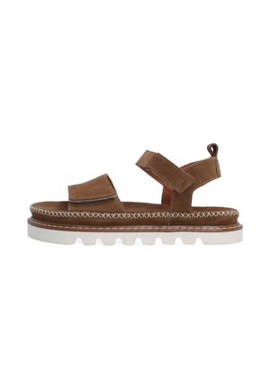 Brune ruskindsandal med justerbare stropper, polstret sål, hvid gummisål og dekorativ syning langs mellemsålet.