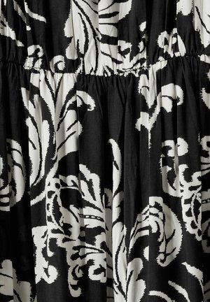 Schwarzer und weißer Stoff mit einem großen Blumenmuster. Das Material ist leicht und hat eine geraffte Textur entlang der Taille.