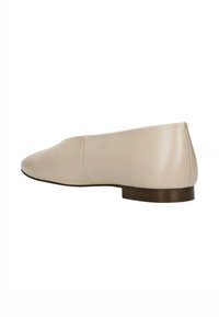 Scarpa piatta in pelle beige con punta tondeggiante, cuciture minime e tacco in legno basso, che presenta una texture liscia e delicata.