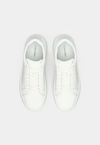 White sneakers with smooth leather, tonal laces, embossed pattern on the sides, and a minimalist design. Logo printed inside.
