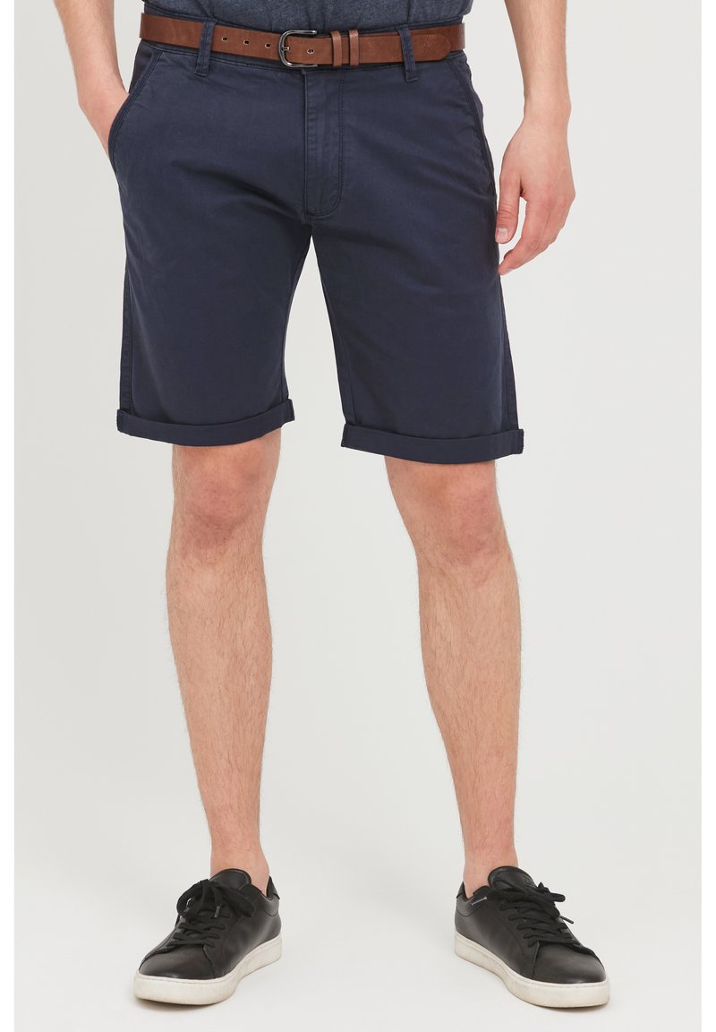 Marineblaue Shorts aus Baumwolle mit klassischem Design, umgeschlagenem Saum, Fronttaschen und einem braunen Ledergürtel.