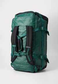 Large duffel bag in dark green and black, made of durable fabric. Features padded shoulder straps, side buckles, and zipper pockets.