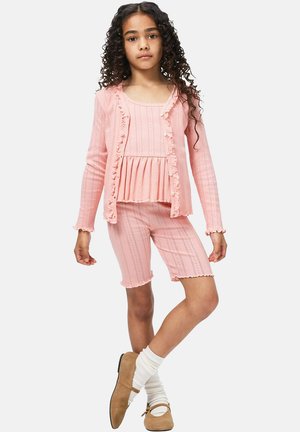 Roze gebreide tweedelige outfit met een cardigan met ruches, een geplooide top en bijpassende korte broek met geschulpte randen, allemaal met een getextureerd ontwerp.