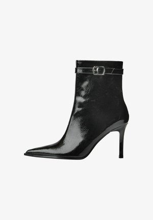 Botină neagră din piele lacuită, cu vârf ascuțit, toc subțire înalt și curea decorativă cu cataramă argintie aproape de partea superioară.