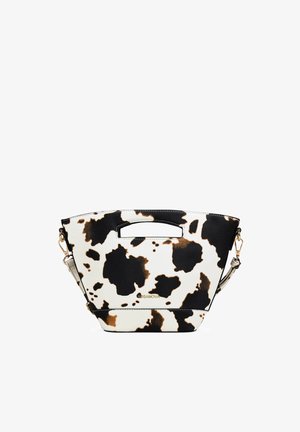 Pequeño bolso trapezoidal con estampado de vaca en negro, blanco y marrón, asa recortada en la parte superior, correa desmontable y logo dorado "BOSANOVA" en el frente.