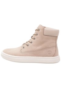 Beige suede high-top sneaker with a cushioned collar, round toe, and metal eyelets. Features a white rubber sole and embossed logo detail.