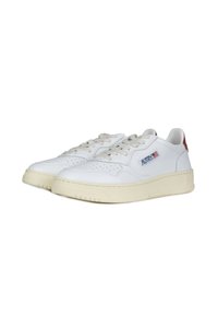 Sneakers bianchi in pelle con una texture liscia, dettagli perforati, suole beige e un accento rosso sul tallone. Presentano il logo sul lato.