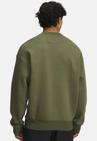 Olivno zelen sweatshirt iz mehkega materiala, s sproščenim krojem, rebrastimi manšeti in robom ter majhnim poudarkom na hrbtni strani vratu.