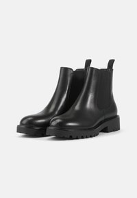 Zwarte leren Chelsea-boots met elastische zijpanelen, ronde neus en dikke rubberen zool met een gestructureerd profiel.