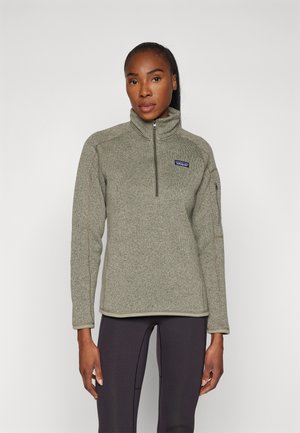 Groene fleece pullover met een halve rits aan de voorkant, geribbelde kraag en contrasterende stiksels. Bevat een logo op de linkerborst en lange mouwen.