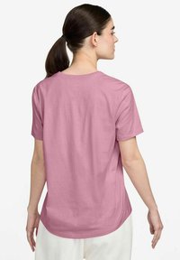 Maglietta rosa a maniche corte vista da dietro, con orlo dritto e texture del tessuto liscia. Design semplice e senza decorazioni.