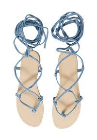 Sandali blu con lacci, dotati di una suola piatta color beige e cinturini incrociati. Cinturini realizzati in tessuto morbido, legati attorno alle caviglie.