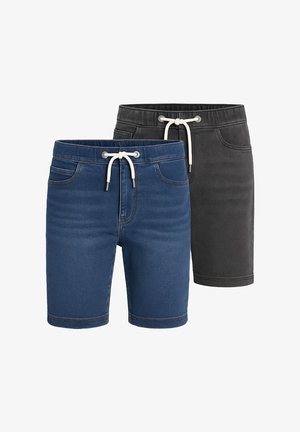 Lys pink bomulds t-shirt med korte ærmer og et lille brystlogo, parret med blå denim shorts og røde og hvide sneakers.