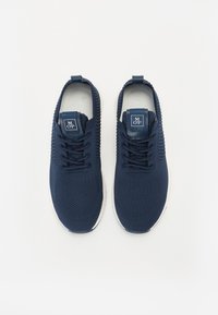 Navy blue athletic shoes made of breathable knit material, featuring lace-up design, textured side panels, and white rubber outsole.