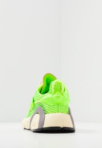 Neon-grüne Netzsneaker mit strukturiertem Fersenbereich, hellbeiger Sohle und grauen Akzenten. Verfügt über eine Zuglasche und ein eng anliegendes Design.