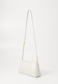 Bílá kožená taška přes rameno s štíhlým, obdélníkovým tvarem, vybavená dlouhým, nastavitelným popruhem a zlatými kovovými detaily.