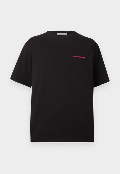 T-shirt noir à manches courtes et col rond avec un petit texte rouge « LES BENJAMINS » sur le côté gauche de la poitrine, sur un fond blanc uni.