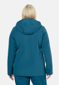 Giacca impermeabile teal con cappuccio, caratterizzata da una texture liscia, taglio dritto e polsini regolabili, progettata per garantire calore e comfort ottimali.