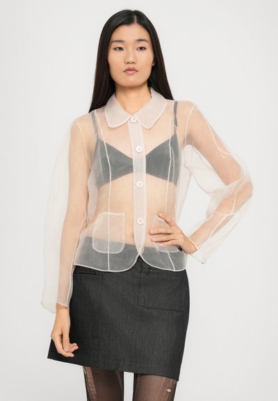 Läbipaistev roosa pluus, millel on krae, pikad puhvbluusikätised, nööpide sulgemine ja tasku detailid, kihtidena tumehall särk ja seelik.