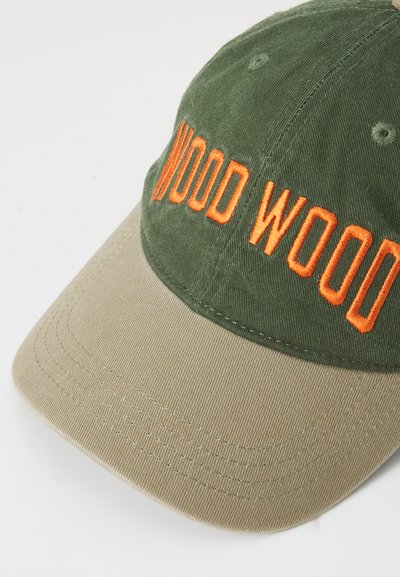 Grønn og tan baseballcaps med brodert "WOOD WOOD" i oransje. Har en buet skjerm og stofftekstur i bomull.