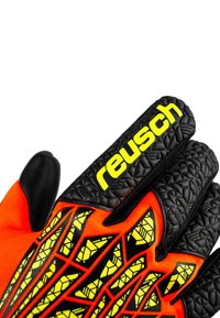 Gants de gardien de but avec une paume en latex noir, un dos en tissu orange, des accents jaunes, un motif de grip texturé et le logo "Reusch".