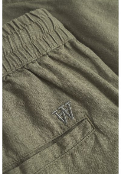 Țesătură de in verde măslinie cu un talie plisată, având un mic logo brodat "W" și un detaliu de buzunar lateral.