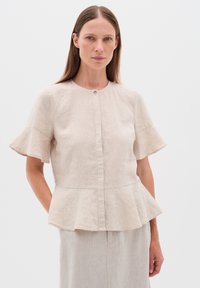 Lněná béžová blůza s peplum střihem, krátkými rozšířenými rukávy, kulatým výstřihem a zapínáním na knoflíky vpředu. Hladký materiál s přirozeným finišem.