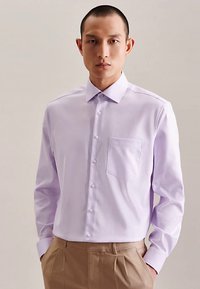 Camicia a maniche lunghe color lilla chiaro con colletto abbottonato, taschino singolo sul petto e chiusura frontale con bottoni, realizzata in tessuto liscio.