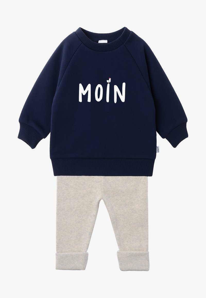 Navy blue cotton sweatshirt with “MOIN” in white letters, paired with light gray ribbed leggings. Sweatshirt features ribbed cuffs and hem.