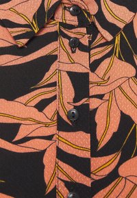 Chemise à manches courtes en tissu noir avec un motif de feuilles roses et des accents jaunes ; comprend une patte de boutonnage avec des boutons noirs.