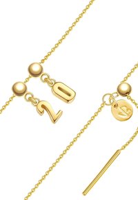 Guldhalsband med en hängande "20"-berlock, sfäriska dekorationer och en liten rund charm med bladdesign.