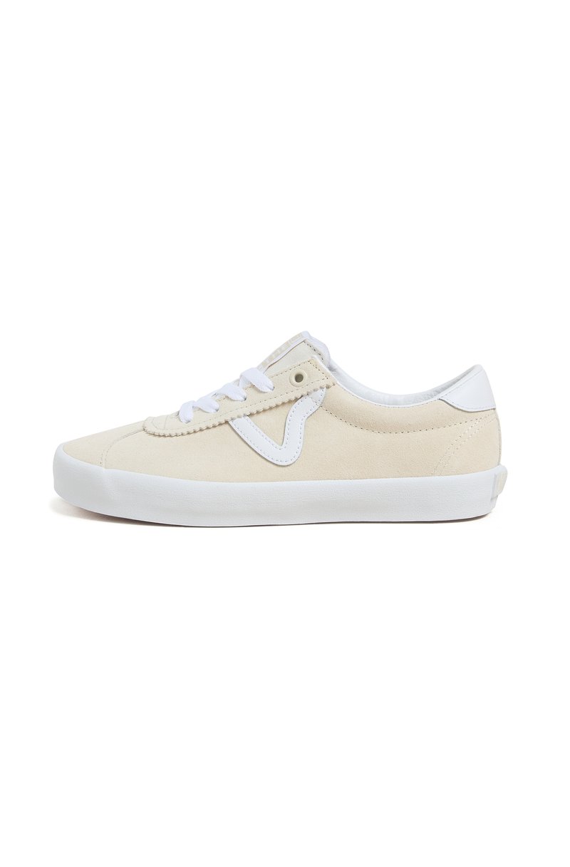 Beige suede sneaker with white accents, lace-up design, rounded toe, and textured surface. Flat rubber sole for grip and comfort.